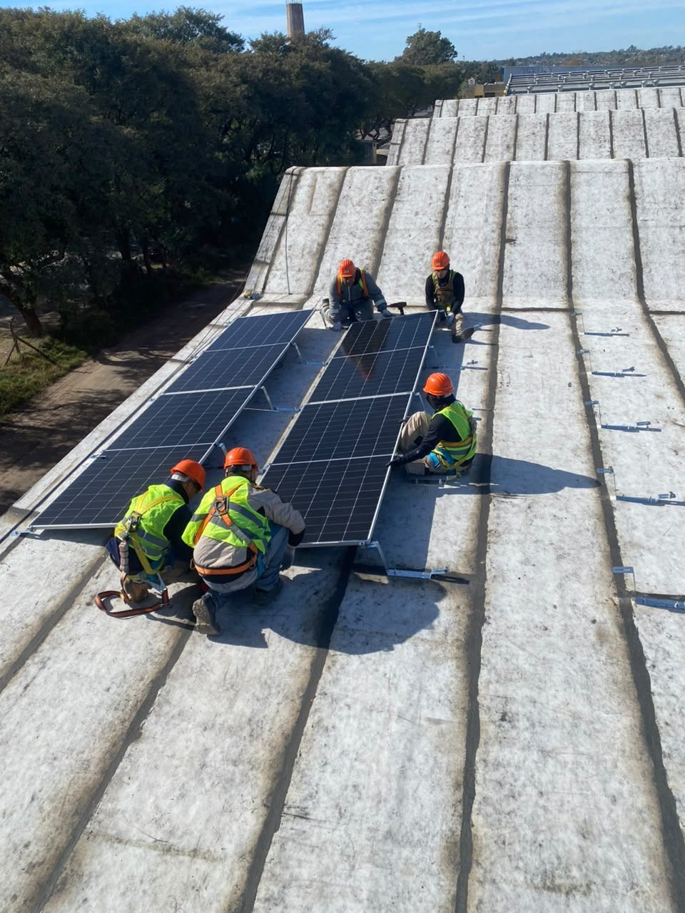 Cuadrilla montando paneles solares sobre un techo